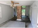 Living room featuring a brick column, sliding glass doors to deck, and a unique ceiling fan at 211 Putnam St, Shelby, NC 28152