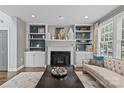 Cozy living room with built-in shelving, fireplace, and large windows for natural light at 224 Wendover Heights Cir, Charlotte, NC 28211