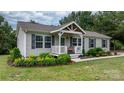 Charming single-story home featuring a covered porch, gray siding, black shutters, and manicured landscaping at 2843 Hopewell Church Rd, Sherrills Ford, NC 28673