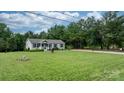 Well-maintained home surrounded by lush greenery, a spacious lawn, and mature trees on a sunny day at 2843 Hopewell Church Rd, Sherrills Ford, NC 28673