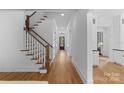 Bright foyer featuring hardwood floors, a staircase with white risers, and hallway with views to back at 2941 Forest Park Dr, Charlotte, NC 28209