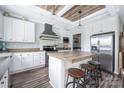 Well-appointed kitchen with white cabinets, wood countertops, an island with seating and stainless steel appliances at 326 Teeter Rd, Mooresville, NC 28115