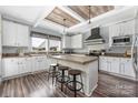 Bright kitchen features white cabinetry, wood-look floors, modern appliances and a central island with seating at 326 Teeter Rd, Mooresville, NC 28115