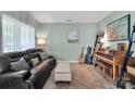 Comfortable living room with tile floors, leather sofa, and musical instruments at 4502 Magnolia Ridge Dr, Waxhaw, NC 28173