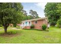 Well-maintained brick home surrounded by green lawns and mature trees at 4533 Gainesborough Rd, Charlotte, NC 28205