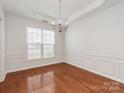 Bright dining room featuring hardwood floors, elegant trim, and a decorative chandelier at 5306 Prosperity View Dr, Charlotte, NC 28269
