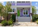 Charming front porch with rocking chairs, flag, potted plants, a green door and a welcoming brick and stone entryway at 536 Spring Landing Dr, Rock Hill, SC 29730