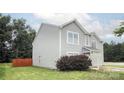 Side view of a home with light gray siding, green grass, and a wooden fence at 585 Gentle Breeze Ln, Rock Hill, SC 29730