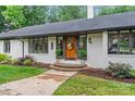 Inviting home entrance with a wooden door, brick steps, and lush landscaping at 625 S Magnolia St, Mooresville, NC 28115