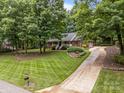 Beautiful, long driveway leads to a brick home surrounded by mature trees and a manicured lawn at 635 Timberlane Trl, Salisbury, NC 28147