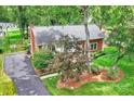 Aerial view of a home with a brick exterior, showcasing landscaping, driveway, and a peaceful surrounding at 7050 Knightswood Dr, Charlotte, NC 28226