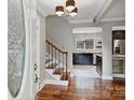 Inviting foyer with hardwood floors, a staircase with wood and black metal railings, and views into the kitchen at 7050 Knightswood Dr, Charlotte, NC 28226
