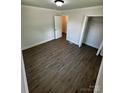 An open bedroom featuring wood-look flooring, a closet, and an open doorway at 801 Calhoun St, Lancaster, SC 29720