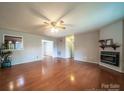 Spacious living room features hardwood floors, a ceiling fan, and a cozy fireplace at 8259 Camelia Ln, Denver, NC 28037
