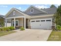 Charming gray home featuring a well-manicured lawn, a two-car garage, and a covered front porch entry at 9009 Myrna Dr, Gastonia, NC 28056