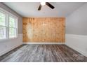 Cozy bedroom with a charming accent wood wall, ceiling fan, and ample natural light at 1010 Fallston Rd, Shelby, NC 28150