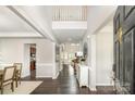 Bright foyer with dark wood flooring, white trim, tall ceilings, and open access to the dining room and main living area at 10198 Tintinhull Dr, Fort Mill, SC 29707