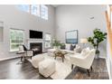 Bright living room with high ceilings, a cozy fireplace, large windows, and contemporary furniture for a welcoming atmosphere at 10198 Tintinhull Dr, Fort Mill, SC 29707