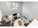 Aerial view of the well-lit living room, showcasing the fireplace, high ceilings, and stylish, modern furniture at 10198 Tintinhull Dr, Fort Mill, SC 29707