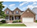 Classic brick home with a welcoming front porch and attached garage at 10198 Tintinhull Dr, Indian Land, SC 29707