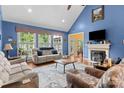 Bright living room with vaulted ceiling, fireplace, hardwood floors, and an abundance of natural light from large windows at 1369 Timberlane Ter, Mooresville, NC 28115