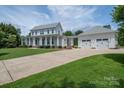 Inviting two-story home with a large front yard, driveway, and a detached three-car garage at 1621 Lakefield Cir, Gastonia, NC 28056