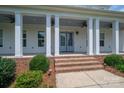 Covered front porch with brick steps and white columns, enhanced by ceiling fans at 1621 Lakefield Cir, Gastonia, NC 28056