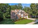 An eye-level view of the property with healthy grass, green shrubs, a large brick home, and a two-car garage at 1747 30Th Avenue Ne Dr, Hickory, NC 28601