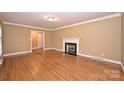 Spacious living room with hardwood floors, a classic fireplace, and elegant crown molding at 1961 Runnymede Ln, Charlotte, NC 28211