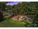 Backyard with a custom brick fire pit and seating area overlooking serene water at 2010 Dogwood Trl, Shelby, NC 28150