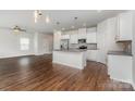 Open-concept kitchen boasts a large island with stainless steel appliances and wood floors at 2039 Sadler Woods Ln, Charlotte, NC 28214