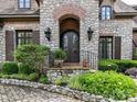 A close-up of the front entrance revealing stone and brick architecture and a decorative wrought iron door at 2240 La Maison Dr, Charlotte, NC 28226