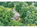 A captivating aerial view showcases a home nestled in a lush, mature forest, offering a serene and private setting at 2314 Winding Oaks Trl, Waxhaw, NC 28173