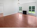 Open living room with hardwood floors, a fireplace, and plenty of natural light at 2479 N Legacy Park Blvd, Fort Mill, SC 29707