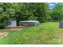 The backyard features green grass, a shed, and a boat parked on a trailer at 301 Honeywood Ave, Charlotte, NC 28216
