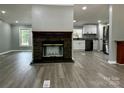 Open-concept living space featuring a stone fireplace and modern gray vinyl flooring at 5458 Foxcroft Dr, Fort Lawn, SC 29714