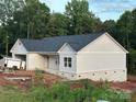 Charming single story home with light gray siding, a dark roof, and a brick foundation in a wooded area at 63 Cornerstone Dr, Taylorsville, NC 28681