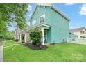 Beautiful home with manicured lawn, and side yard featuring lush greenery and a well-maintained garden at 7931 Baylis Dr, Huntersville, NC 28078
