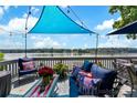 Inviting outdoor deck area with comfortable seating and patriotic decor overlooking a serene lake at 812 Bell Post Rd, Belmont, NC 28012