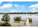 Picturesque view of a private boathouse and dock on a tranquil lake under a bright sky at 812 Bell Post Rd, Belmont, NC 28012