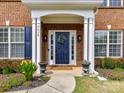 Close-up of a welcoming front door with a wreath and colorful flower arrangements at 8608 Talbert Paige Ct, Charlotte, NC 28277