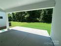 Relaxing covered patio with a view of the expansive, well-maintained backyard lawn and surrounding trees at 9108 Dulwich Dr # Ken0074, Charlotte, NC 28215