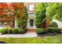 Elegant front entrance with a classic black door, brick steps, and lush green landscaping at 11139 Tradition View Dr, Charlotte, NC 28269