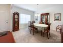 Classic dining room featuring a wooden table set for four, with a grandfather clock and traditional decor at 1228 Tranquil Falls Ln, Matthews, NC 28104