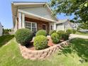 A cozy home with brick accents, manicured bushes, and a tidy front yard, offering curb appeal at 1228 Tranquil Falls Ln, Matthews, NC 28104