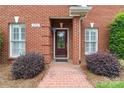 Inviting entryway with a brick pathway, decorative shrubs, and a classic front door at 1302 Warrington Pl, Rock Hill, SC 29732