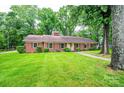 Traditional brick home with lush green lawn and mature trees providing shade at 1304 5Th Street Nw Cir, Hickory, NC 28601