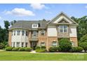 Charming two-story home with a well-manicured lawn, attractive brickwork, and decorative shutters at 16229 Loch Raven Rd, Huntersville, NC 28078