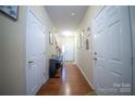 Inviting hallway with hardwood floors, white doors, and neutral walls creating a welcoming atmosphere at 16525 Kettlewell Ln, Charlotte, NC 28277