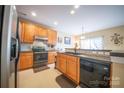 Well-lit kitchen featuring wood cabinets, a black sink, and modern appliances at 16525 Kettlewell Ln, Charlotte, NC 28277